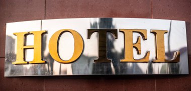 Otel tabelaları, krom ve altın karo duvarda.