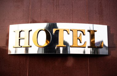 Otel tabelaları, krom ve altın karo duvarda.