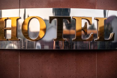 Otel tabelaları, krom ve altın karo duvarda.