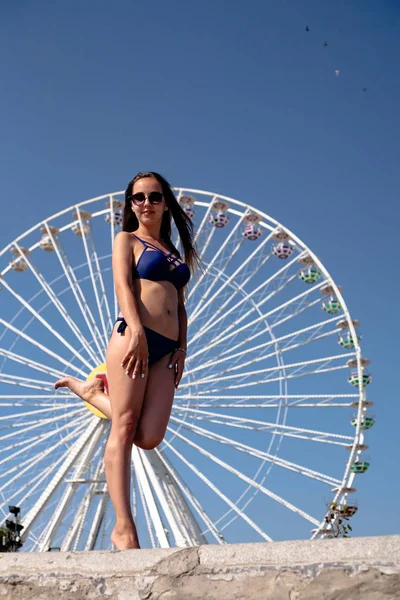 快乐的女孩在摩天轮的背景 度假时穿着泳衣 — 图库照片