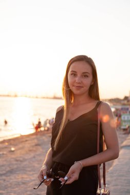 Güzel, genç bir kız gün batımında yürür. Yaşam tarzı özgürlüğü, anın tadını çıkarma kavramı.