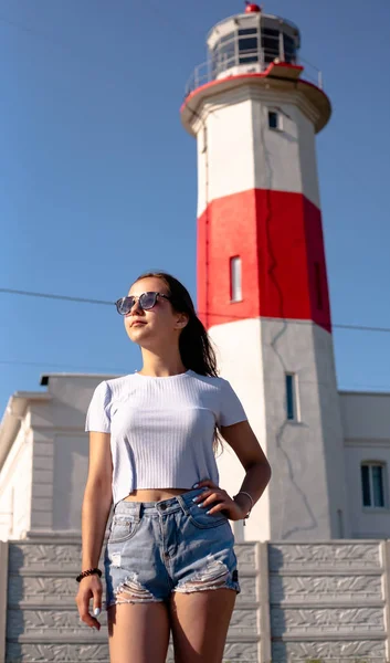 灯台の背景に美しい 自由な女の子 澄んだ青空 — ストック写真