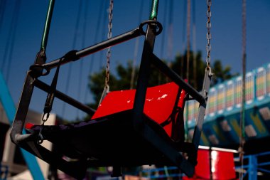 Zincirde oturuyorum. Lunaparkta bir yaz güneşli bir günde Carousel.