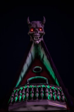 Evin çatısında boynuzları olan şeytan kafası. Arka plan.