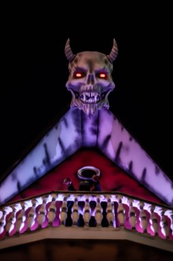 Evin çatısında boynuzları olan şeytan kafası. Arka plan.