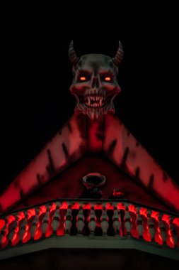 Evin çatısında boynuzları olan şeytan kafası. Arka plan.