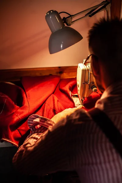 欧洲男子缝制衣服在他的缝纫车间在家里 — 图库照片