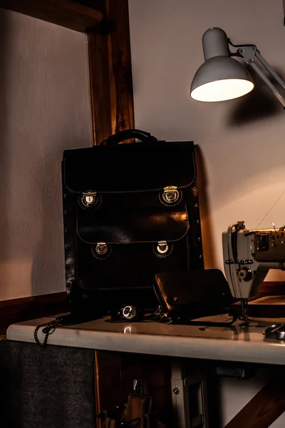 Leather briefcase bag, wallet and handmade watch stand on the table.
