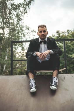 Klasik siyah takım elbiseli bir adam. Kaykay, ücretsiz yaşam konsepti.