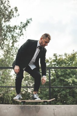 Klasik siyah takım elbiseli bir adam. Kaykay, ücretsiz yaşam konsepti.