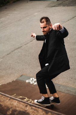 Klasik siyah takım elbiseli bir adam. Kaykay, ücretsiz yaşam konsepti.