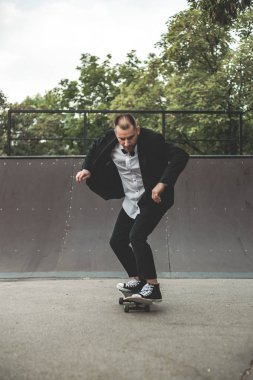 Klasik siyah takım elbiseli bir adam. Kaykay, ücretsiz yaşam konsepti.