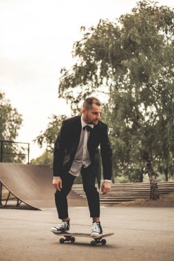 Klasik siyah takım elbiseli bir adam. Kaykay, ücretsiz yaşam konsepti.