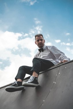 Klasik siyah takım elbiseli bir adam. Kaykay, ücretsiz yaşam konsepti.