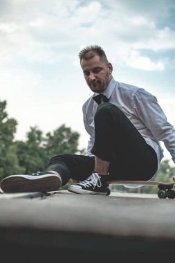 Klasik siyah takım elbiseli bir adam. Kaykay, ücretsiz yaşam konsepti.