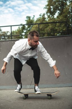 Klasik siyah takım elbiseli bir adam. Kaykay, ücretsiz yaşam konsepti.