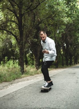 Klasik siyah takım elbiseli bir adam. Kaykay, ücretsiz yaşam konsepti.