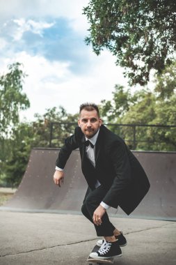 Klasik siyah takım elbiseli bir adam. Kaykay, ücretsiz yaşam konsepti.