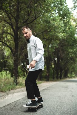 Klasik siyah takım elbiseli bir adam. Kaykay, ücretsiz yaşam konsepti.