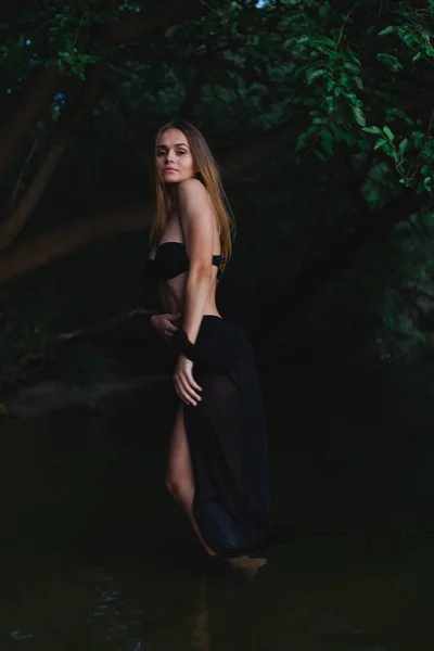 海岸にポーズをとる黒い水着とパレオの美しいモデル — ストック写真