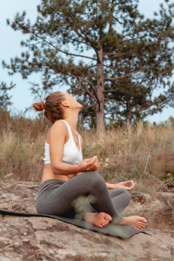 Kız yoga uyguluyor. Adanın dağ ve nehir kıyısında doğa ile çevrili.