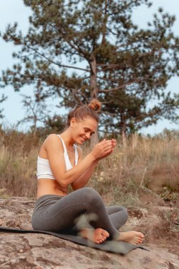Kız yoga uyguluyor. Adanın dağ ve nehir kıyısında doğa ile çevrili.