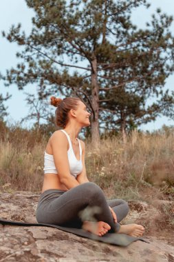 Kız yoga uyguluyor. Adanın dağ ve nehir kıyısında doğa ile çevrili.