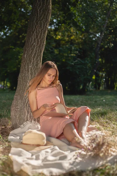 Красивая Девушка Отдыхает Траве Дерева Шляпе Книгой Сушеных Цветов Смартфоном — стоковое фото