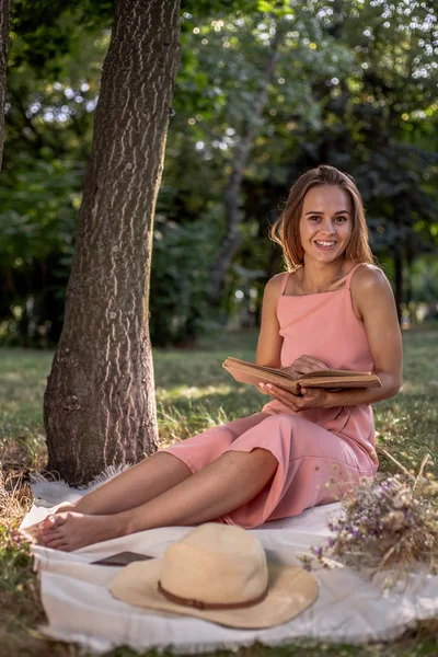 Krásná Dívka Odpočívá Trávě Stromu Klobouku Knihou Sušených Květin Smartphone — Stock fotografie