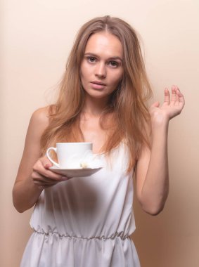 Genç bir kadın bir fincan kahvenin tadını çıkarıyor. Sabah çayı ile kadın portresi. Kopyalama alanı