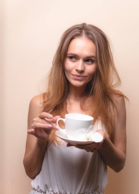 Genç bir kadın bir fincan kahvenin tadını çıkarıyor. Sabah çayı ile kadın portresi. Kopyalama alanı