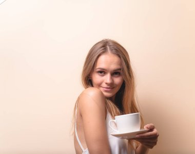 Genç bir kadın bir fincan kahvenin tadını çıkarıyor. Sabah çayı ile kadın portresi. Kopyalama alanı