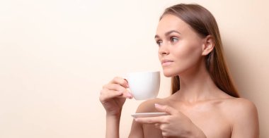 Genç bir kadın bir fincan kahvenin tadını çıkarıyor. Sabah çayı ile kadın portresi. Kopyalama alanı