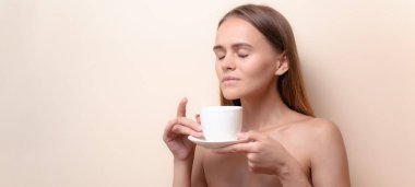 Genç bir kadın bir fincan kahvenin tadını çıkarıyor. Sabah çayı ile kadın portresi. Kopyalama alanı