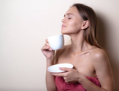 Genç bir kadın bir fincan kahvenin tadını çıkarıyor. Sabah çayı ile kadın portresi. Kopyalama alanı