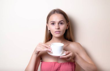 Genç bir kadın bir fincan kahvenin tadını çıkarıyor. Sabah çayı ile kadın portresi. Kopyalama alanı