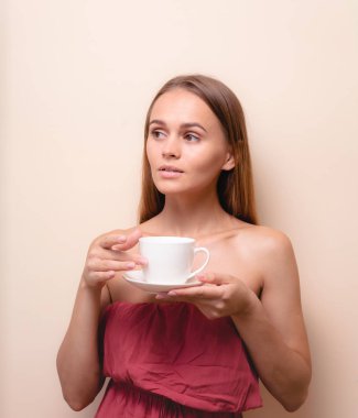 Genç bir kadın bir fincan kahvenin tadını çıkarıyor. Sabah çayı ile kadın portresi. Kopyalama alanı