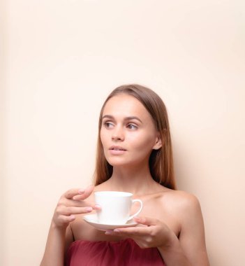 Genç bir kadın bir fincan kahvenin tadını çıkarıyor. Sabah çayı ile kadın portresi. Kopyalama alanı