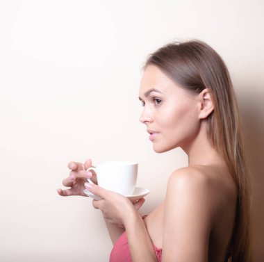 Genç bir kadın bir fincan kahvenin tadını çıkarıyor. Sabah çayı ile kadın portresi. Kopyalama alanı