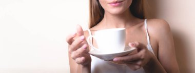 Genç bir kadın bir fincan kahvenin tadını çıkarıyor. Sabah çayı ile kadın portresi. Kopyalama alanı