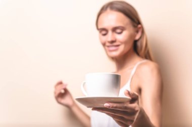 Genç bir kadın bir fincan kahvenin tadını çıkarıyor. Sabah çayı ile kadın portresi. Kopyalama alanı