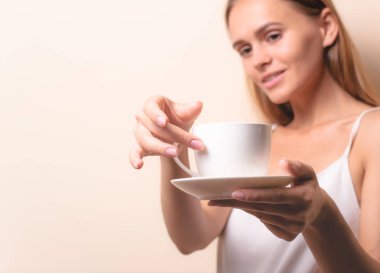 Genç bir kadın bir fincan kahvenin tadını çıkarıyor. Sabah çayı ile kadın portresi. Kopyalama alanı