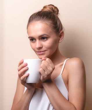 Genç bir kadın bir fincan kahvenin tadını çıkarıyor. Sabah çayı ile kadın portresi. Kopyalama alanı