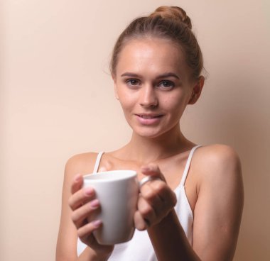 Genç bir kadın bir fincan kahvenin tadını çıkarıyor. Sabah çayı ile kadın portresi. Kopyalama alanı