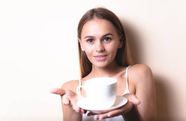 Genç bir kadın bir fincan kahvenin tadını çıkarıyor. Sabah çayı ile kadın portresi. Kopyalama alanı