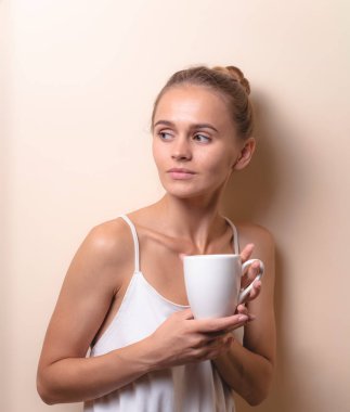 Genç bir kadın bir fincan kahvenin tadını çıkarıyor. Sabah çayı ile kadın portresi. Kopyalama alanı