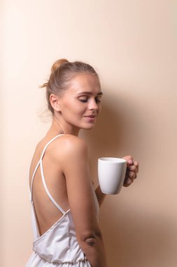 Genç bir kadın bir fincan kahvenin tadını çıkarıyor. Sabah çayı ile kadın portresi. Kopyalama alanı