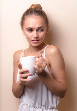 Genç bir kadın bir fincan kahvenin tadını çıkarıyor. Sabah çayı ile kadın portresi. Kopyalama alanı