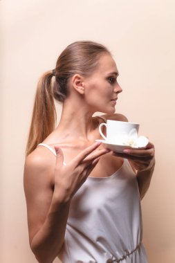 Genç bir kadın bir fincan kahvenin tadını çıkarıyor. Sabah çayı ile kadın portresi. Kopyalama alanı