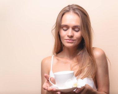 Genç bir kadın bir fincan kahvenin tadını çıkarıyor. Sabah çayı ile kadın portresi. Kopyalama alanı